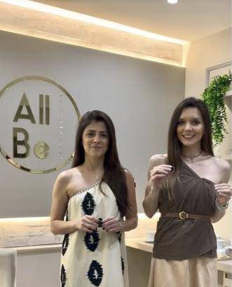 As arquitetas Ariana Pego e Fernanda Savi no escritório da AllBe, em frente ao logo na parede